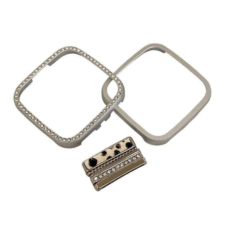May include: A set of three silver-toned watch bands. One band is adorned with rhinestones, another is plain, and the third has a leopard print design with rhinestones.