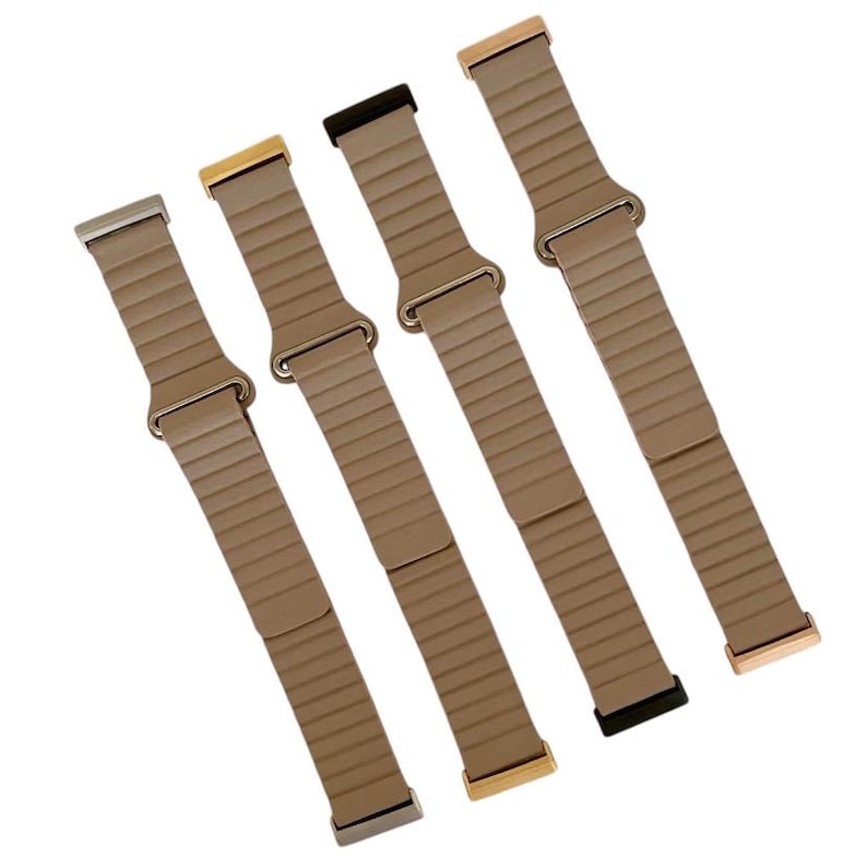 Peut inclure: Quatre bracelets de montre en m&eacute;tal de couleurs diff&eacute;rentes avec un bracelet en m&eacute;tal brun textur&eacute;. Les bracelets sont en or, argent, or rose et noir.