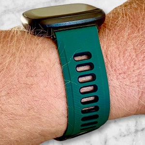 Pu&ograve; includere: Un cinturino per orologio in silicone verde scuro con accenti neri e fori di ventilazione.