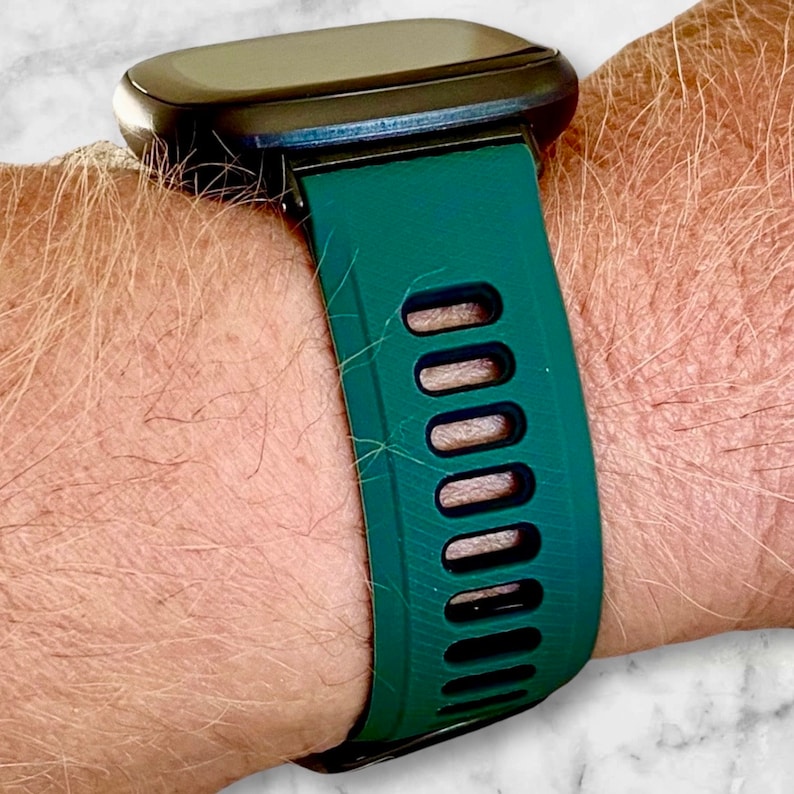 Pu&ograve; includere: Un cinturino per orologio in silicone verde scuro con accenti neri e fori di ventilazione.