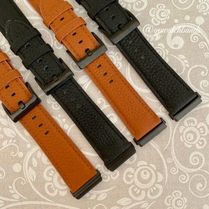 May include: Four watch bands in two different colors. Two are brown leather with black stitching and two are black leather with white stitching. All bands have a black metal buckle.