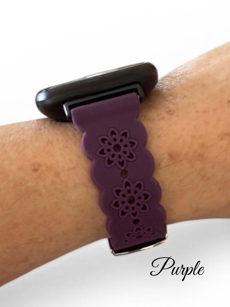 May include: A purple watch band with a floral design. The band is attached to a black watch face. The word "Purple" is written in cursive at the bottom of the image.