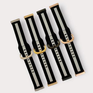 May include: Five different watch bands with black and silver stripes. The bands have different colored buckles: rose gold, gold, silver, and black.