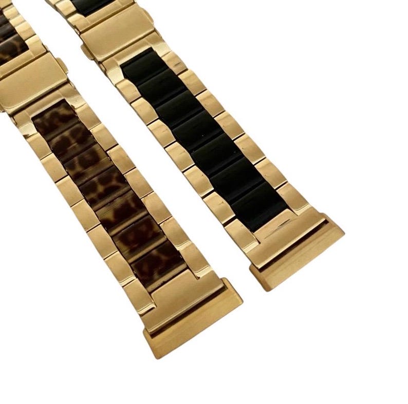 Puede incluir: Dos correas de reloj de tono dorado. Una correa tiene un inserto de cer&aacute;mica negra, la otra tiene un inserto de estampado de leopardo marr&oacute;n.
