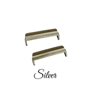 May include: Two silver metal watch band spring bars. The spring bars are designed to hold a watch band in place.