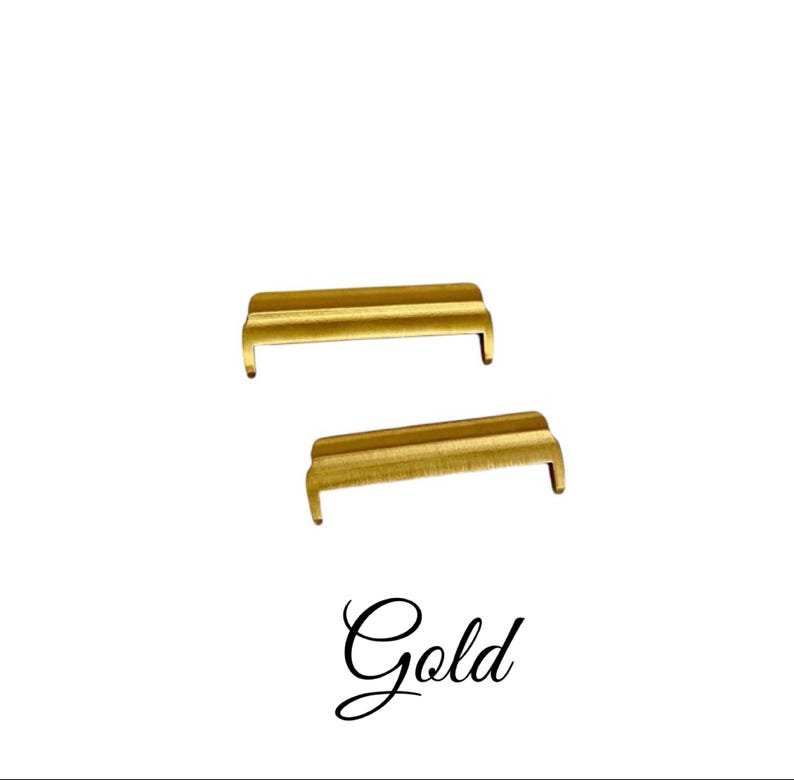 May include: Two gold-colored metal watch band spring bars. The spring bars are about 1.5 inches long.