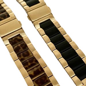 Puede incluir: Dos correas de reloj de tono dorado. Una correa tiene un acabado de cer&aacute;mica negra, la otra tiene un dise&ntilde;o de estampado de leopardo marr&oacute;n y negro.