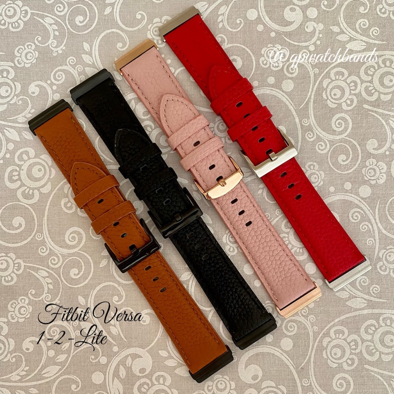 May include: Four different colored leather watch bands for the Fitbit Versa 1-2 Lite. The bands are brown, black, pink, and red.