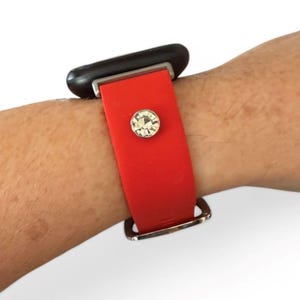 Peut inclure: Bracelet de montre rouge avec une boucle argent&eacute;e et un accent en cristal &eacute;tincelant. Le bracelet est fix&eacute; &agrave; un cadran de montre noir. La bande est faite d'un mat&eacute;riau souple.