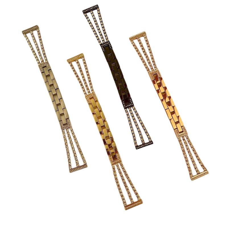 Pu&ograve; includere: Quattro cinturini per orologio con un design a catena a maglie. I cinturini sono in oro, argento e nero.
