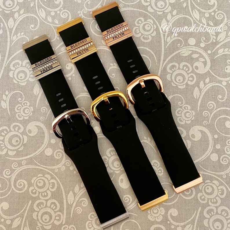 K&ouml;nnte beinhalten: Drei schwarze Silikon-Armb&auml;nder mit goldenen, silbernen und ros&eacute;goldenen Metall-Anh&auml;ngern, auf denen "Blessed" und "Faith" steht.