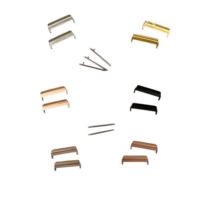 May include: Assortment of watch band spring bars in silver, gold, rose gold, and black. The spring bars are in pairs and are arranged in a grid pattern.