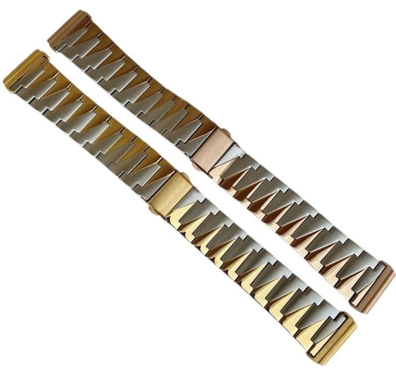 K&ouml;nnte beinhalten: Zwei Uhrenarmb&auml;nder mit geometrischem Design. Eines ist gold- und silberfarben, das andere ros&eacute;gold- und silberfarben. Die Armb&auml;nder sind aus Metall und haben einen Verschluss. Die Armb&auml;nder sind diagonal im Rahmen angeordnet.