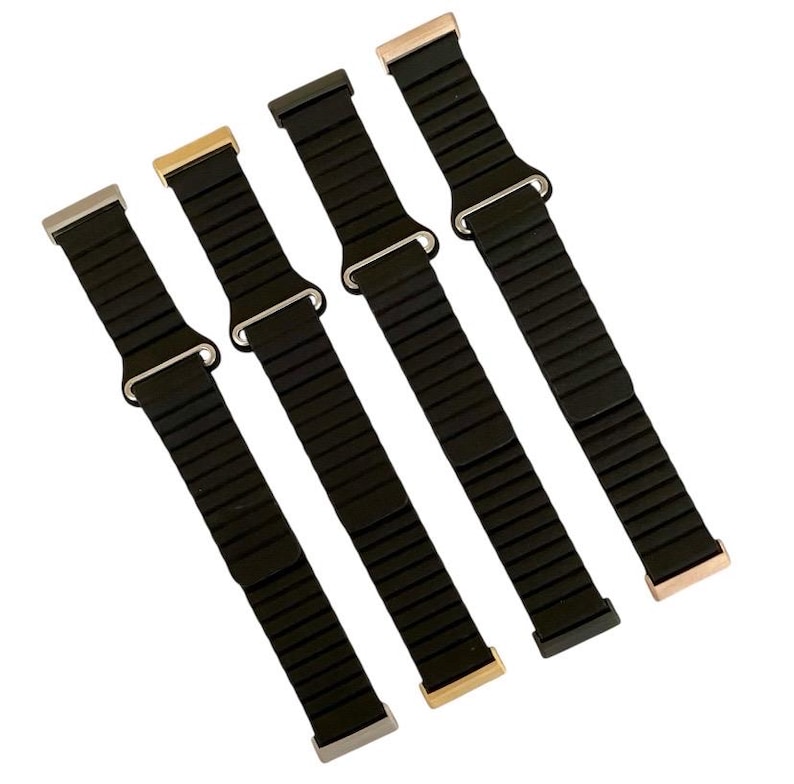 Peut inclure: Quatre bracelets de montre en m&eacute;tal noir avec des fermoirs de diff&eacute;rentes couleurs. Les bracelets sont faits d'un mat&eacute;riau m&eacute;tallique flexible et ont un design &eacute;l&eacute;gant et moderne.