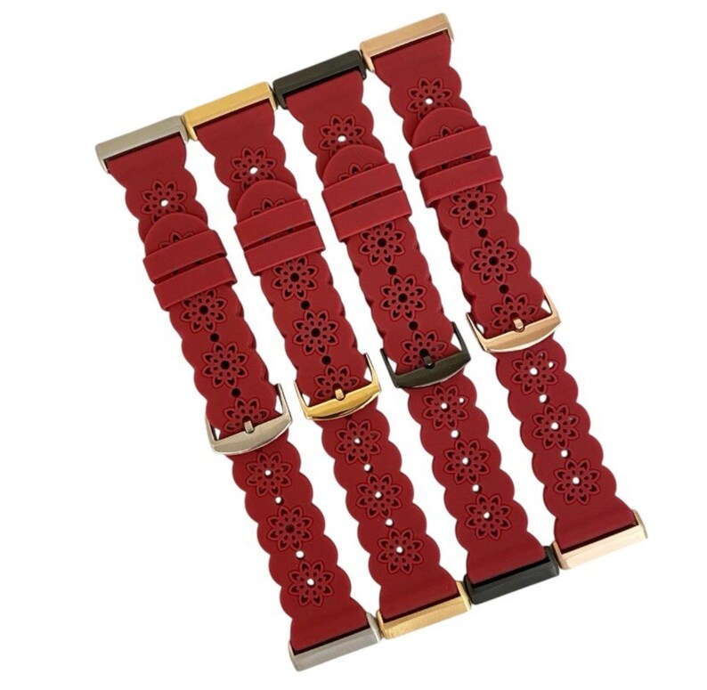 May include: Four red watch bands with floral cutouts and various metal clasps. The bands are made of a flexible material and have a scalloped edge. The clasps are silver, gold, and black.