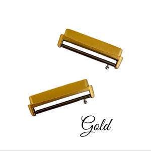 Pu&ograve; includere: Due connettori per cinturino da orologio in metallo color oro. I connettori hanno una fessura per un cinturino da orologio e un piccolo perno sul lato.