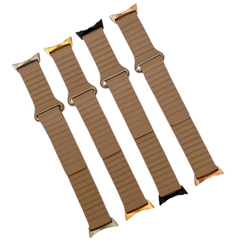 May include: Four different colored Apple Watch bands in a light brown color. The bands are made of a flexible material and have a smooth finish.