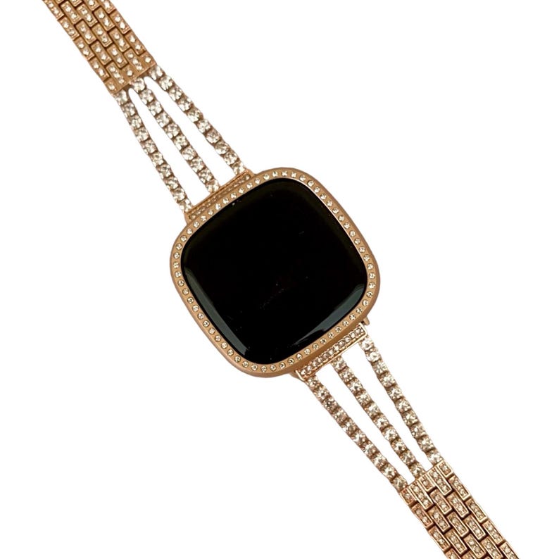 May include: A gold-tone watch with a black face and a diamond-encrusted band.