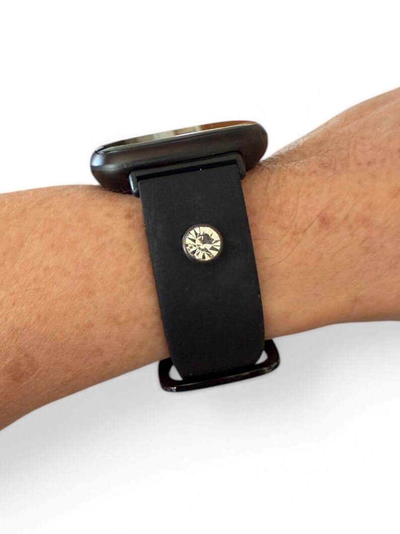 Peut inclure: Bracelet de montre noir avec un grand cadran de montre fonc&eacute;. Le bracelet est orn&eacute; d'un cristal rond et &eacute;tincelant. La montre est con&ccedil;ue pour &ecirc;tre port&eacute;e au poignet.