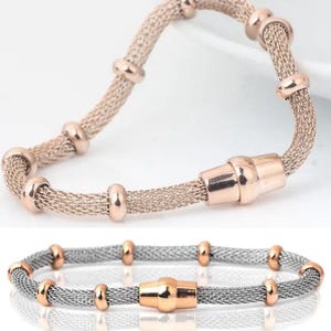 Peut inclure: Deux bracelets. Le bracelet sup&eacute;rieur est en or rose avec un design en maille et des accents en or rose. Le bracelet inf&eacute;rieur est argent&eacute; avec des accents en or rose. Les deux bracelets ont un fermoir magn&eacute;tique.