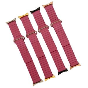 May include: Four pink silicone watch bands with gold and silver clasps. The bands have a ribbed texture.