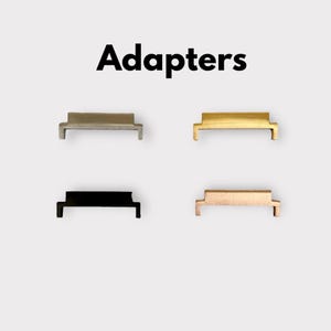 May include: Four watch band adapters in different colours: silver, gold, black, and rose gold. The adapters are designed to connect watch bands to a watch case.