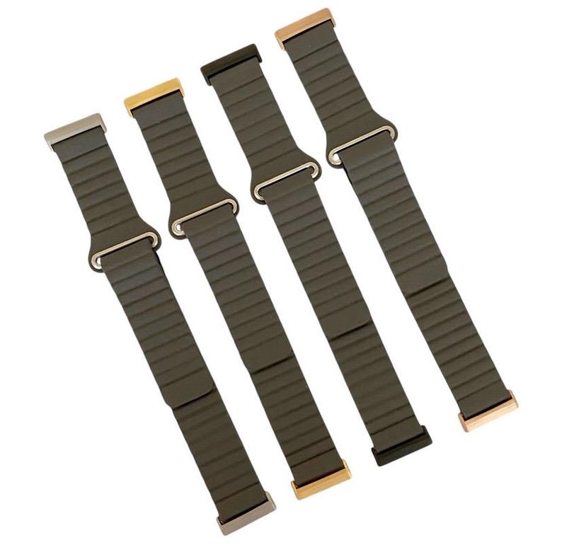 Peut inclure: Quatre bracelets de montre en m&eacute;tal de couleurs diff&eacute;rentes avec une finition vert fonc&eacute;. Les bracelets sont en m&eacute;tal flexible et se ferment par un fermoir.