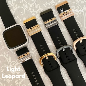 May include: Four black watch bands with different colored buckles and decorative bands. The bands have a leopard print design and are adorned with rhinestones. The text "Light Leopard" is visible in the bottom left corner of the image.
