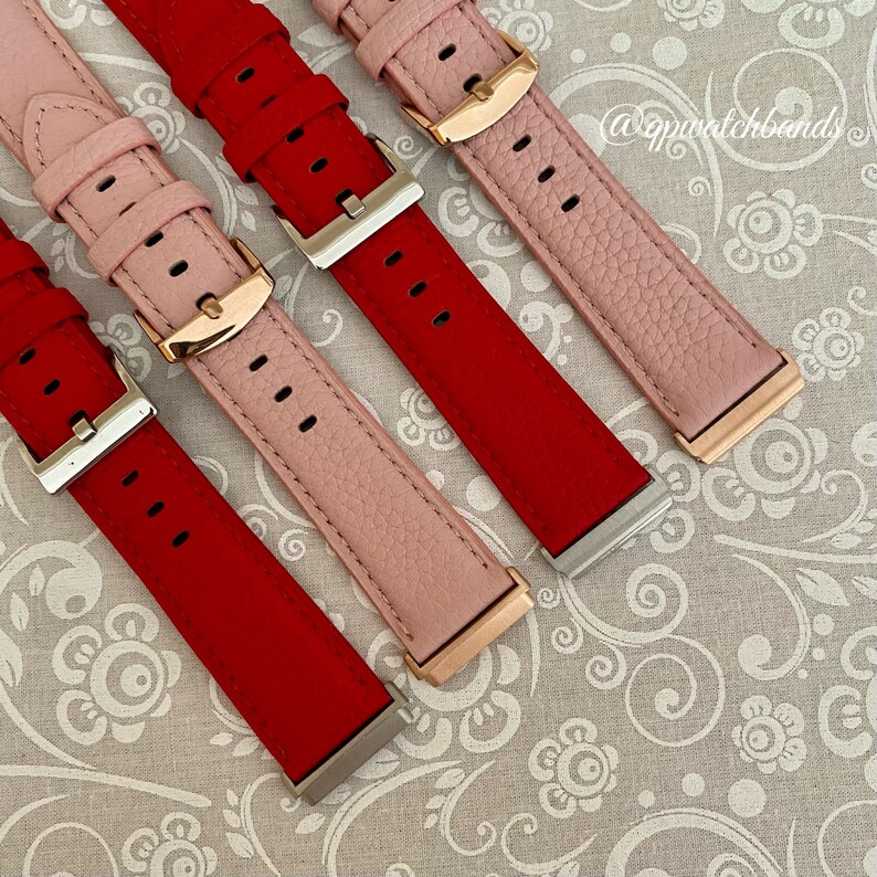 May include: Three watch bands in red, pink, and pink. The bands are made of leather and have a rose gold buckle. The bands are on a white background with a floral pattern.