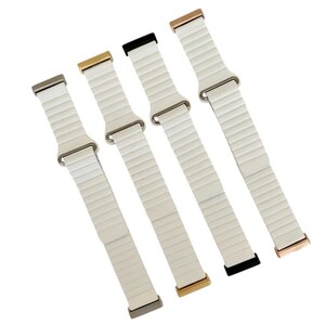 Peut inclure: Quatre bracelets de montre blancs avec des fermoirs de couleurs diff&eacute;rentes. Les bracelets sont en silicone textur&eacute; et ont un design &eacute;l&eacute;gant et moderne.