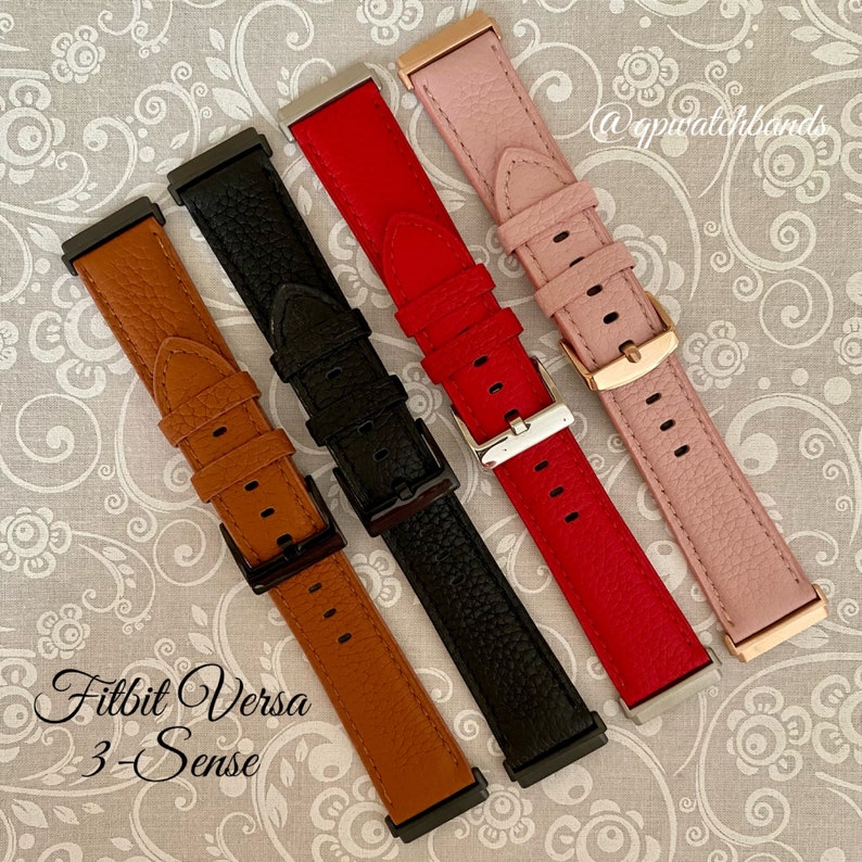 May include: Four different colored leather watch bands for a Fitbit Versa 3-Sense smartwatch. The bands are brown, black, red, and pink.