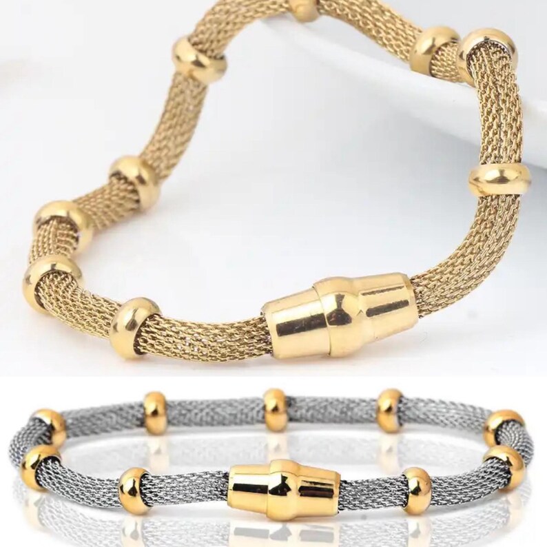 Peut inclure: Deux bracelets, un dor&eacute; et un argent&eacute;. Les deux pr&eacute;sentent un design en maille avec des accents dor&eacute;s et un fermoir magn&eacute;tique. Le bracelet dor&eacute; est en haut, l'argent&eacute; en bas. Circonf&eacute;rence d'environ 18 cm.