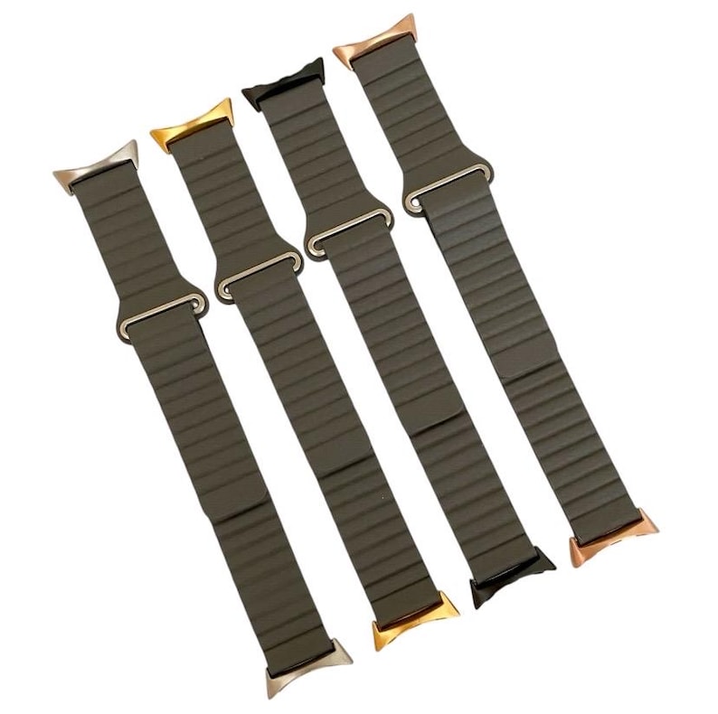 May include: Four different colored watch bands with a dark green silicone strap and a metal buckle. The bands are arranged in a row, with the buckles facing the viewer.