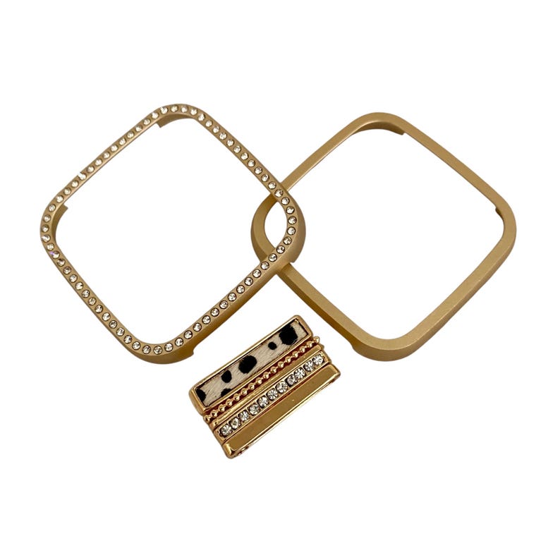 May include: Gold-toned watch band with a decorative, sparkly, square frame and a black and white patterned band with rhinestones.