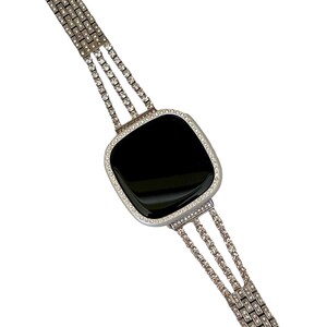May include: A silver watch with a black face and a diamond-encrusted band.