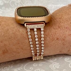 K&ouml;nnte beinhalten: Armband f&uuml;r eine Smartwatch in Ros&eacute;gold mit einer dreifachen Reihe aus klaren Strasssteinen. Das Armband ist f&uuml;r eine quadratische Smartwatch konzipiert.