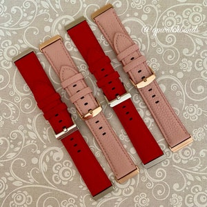 May include: Four leather watch bands in red and pink. The bands are arranged in a fan shape with the ends of the bands facing the viewer. The bands have rose gold hardware.