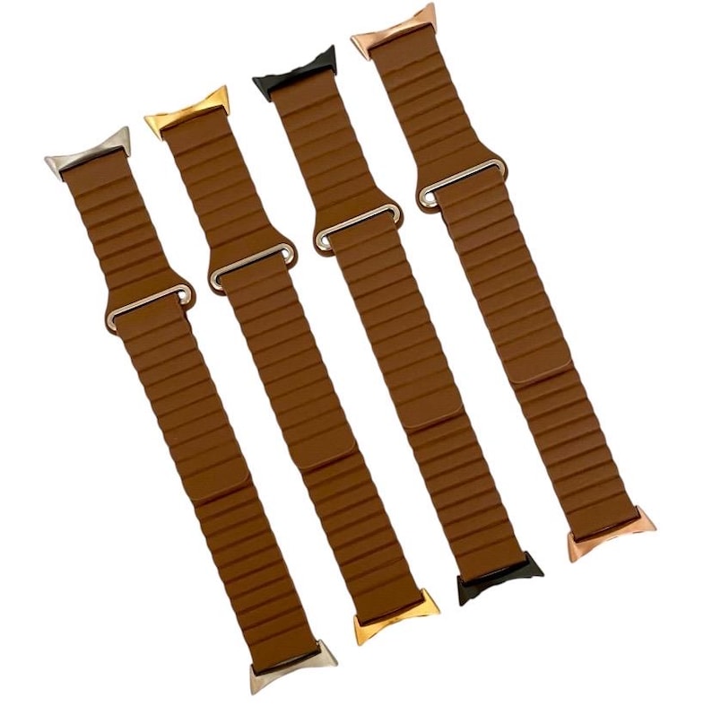May include: Four brown silicone watch bands with different colored metal clasps. The bands have a ribbed texture and are designed for Apple Watch.