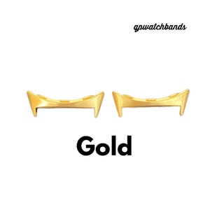 May include: Two gold-coloured metal watch band spring bars. The spring bars are curved and have a slight bend at each end.