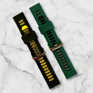 Pu&ograve; includere: Due cinturini per orologio, uno nero con accenti gialli e uno verde. Entrambi i cinturini hanno una fibbia in metallo.
