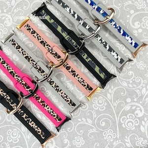 May include: Six different watch straps with a leopard print design. The straps are in various colours, including black, pink, grey, and camouflage. The straps are made of silicone and have a gold buckle.