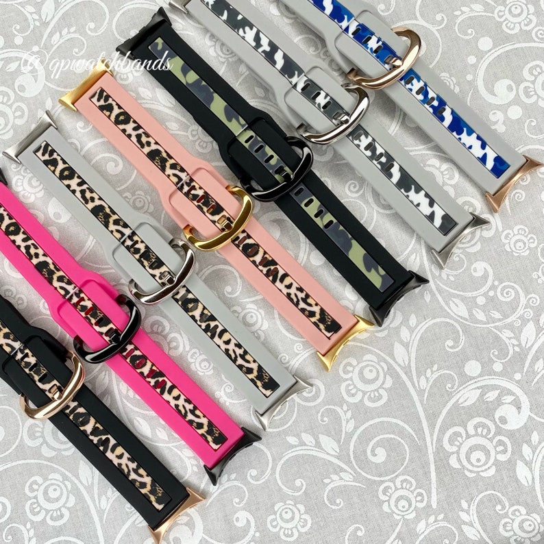 May include: Six different watch straps with a leopard print design. The straps are in various colours, including black, pink, grey, and camouflage. The straps are made of silicone and have a gold buckle.