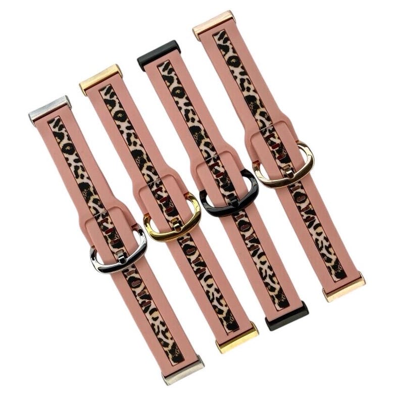 Op de afbeelding: Vier roze siliconen horlogebandjes met een luipaardprint. De bandjes hebben verschillende gekleurde gespen: goud, zilver, zwart en ros&eacute;goud.