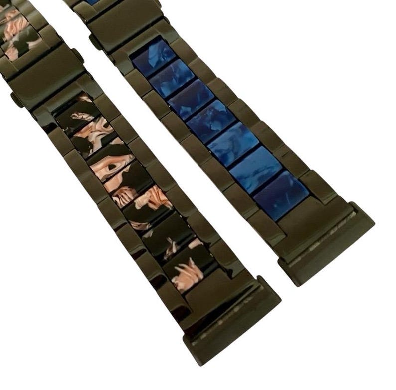 Puede incluir: Dos correas de reloj de metal negro con diferentes patrones de colores. Una correa tiene un patr&oacute;n de m&aacute;rmol azul y blanco, y la otra tiene un patr&oacute;n de m&aacute;rmol rosa y blanco.