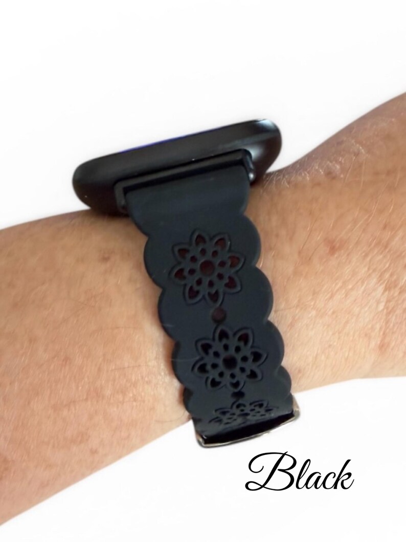 May include: Black smartwatch band with a floral cutout design. The band is attached to a black smartwatch. The word "Black" is written in cursive at the bottom of the image.