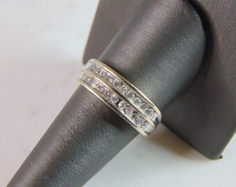 May include: A silver band ring with two rows of small, clear gemstones.