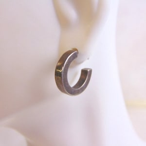 May include: Silver hoop earrings with a slightly squared shape.