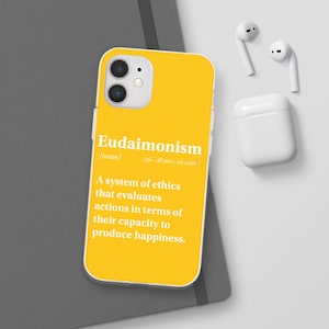 May include: A yellow phone case with a white border and a definition of the word "Eudaimonism" printed on it. The definition reads: "(noun) /ˌyü-ˈdī-mə-ˌni-zəm/ A system of ethics that evaluates actions in terms of their capacity to produce happiness."