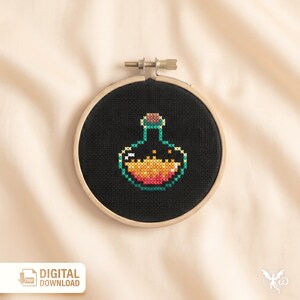 May include: A cross-stitch embroidery hoop featuring a black background with a colorful potion bottle design. The bottle is outlined in green, with orange and yellow filling the interior. The wooden hoop is visible, and the text "DIGITAL DOWNLOAD" is in the lower left corner.