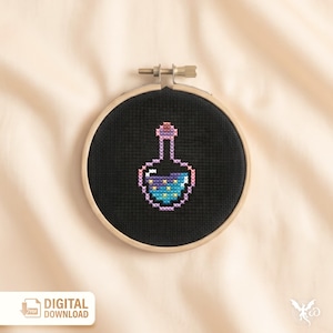 May include: A cross-stitch design of a potion bottle in a wooden embroidery hoop. The bottle is filled with blue liquid and yellow stars, with pink and purple accents. The text "DIGITAL DOWNLOAD" is visible.